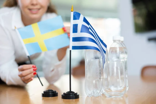 Young Female Assistant Setting Greek Swedish Flags International Negotiations — Stock Photo, Image