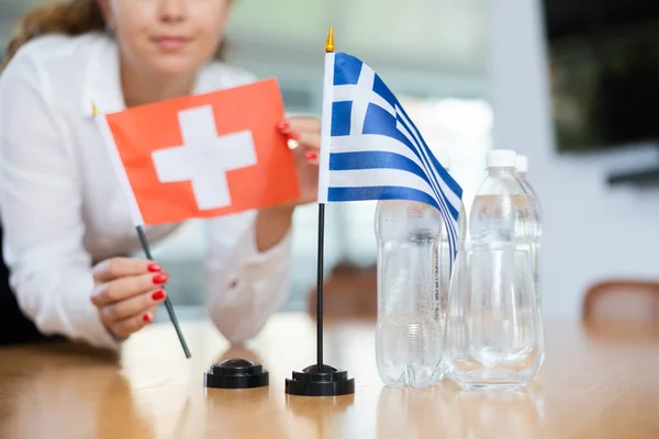 Genç Bayan Asistan Uluslararası Müzakereler Için Yunanca Sviçre Bayrakları Kuruyor — Stok fotoğraf