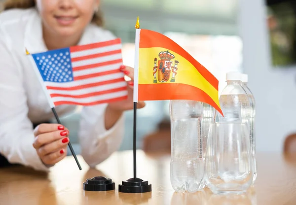 Young Woman Business Clothes Puts Flags Usa Spain Negotiating Table — Stock Photo, Image