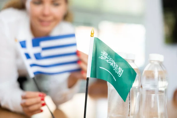 Подготовка Деловым Переговорам Женщина Ставит Стол Небольшие Флаги Стран Саудовской — стоковое фото