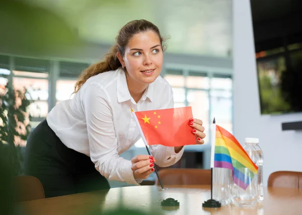 Ung Kvinna Affärskläder Sätter Flaggor Kina Och Hbt Förhandlingsbordet Ämbetet — Stockfoto
