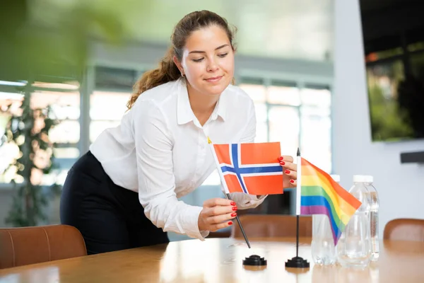 Jonge Vrouw Bedrijfskleding Zet Vlaggen Van Noorwegen Lgbt Onderhandelingstafel — Stockfoto