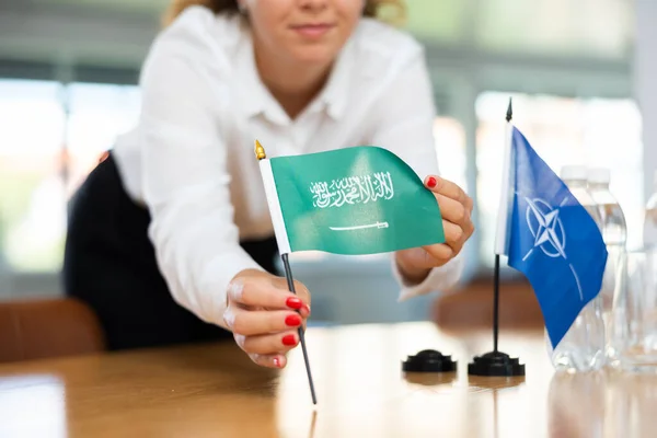 Młoda Asystentka Zakładająca Flagi Nato Saudi Arabskie Potrzeby Negocjacji Międzynarodowych — Zdjęcie stockowe