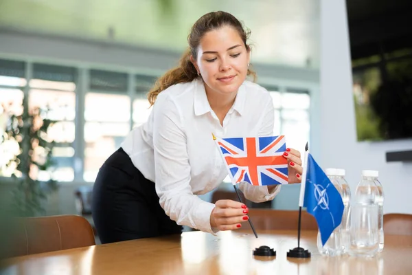 Giovane Assistente Femminile Che Istituisce Bandiere Nato Britannico Negoziati Internazionali — Foto Stock
