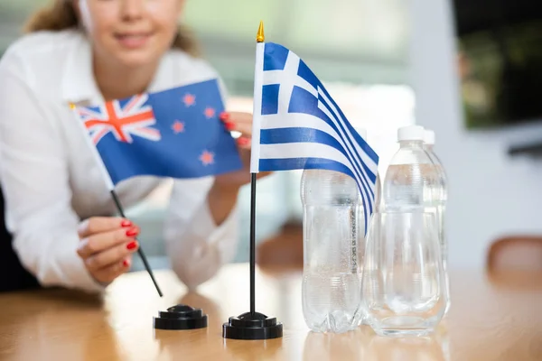 Junge Assistentin Setzt Griechische Und Neue Flaggen Für Internationale Verhandlungen — Stockfoto