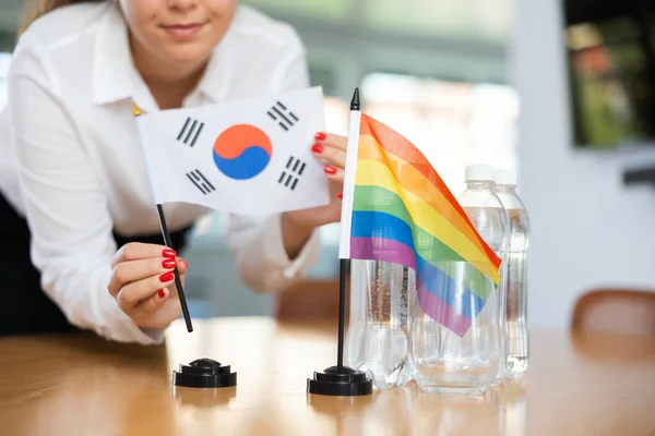 Młoda Kobieta Ubraniu Biznesowym Stawia Flagi Korei Południowej Lgbt Stole — Zdjęcie stockowe