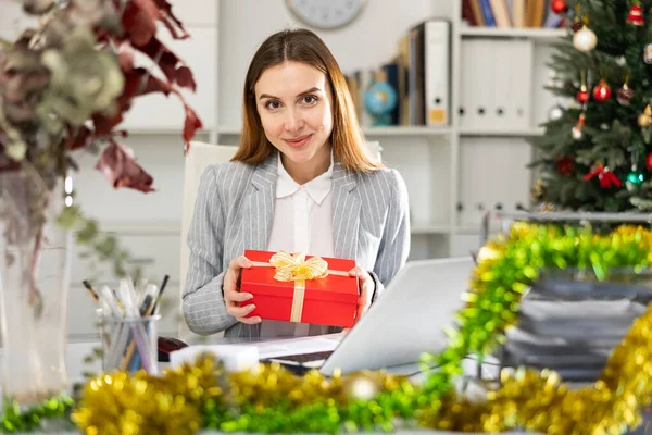 圣诞节前坐在工作场所接受礼物的快乐的女商人的画像 — 图库照片