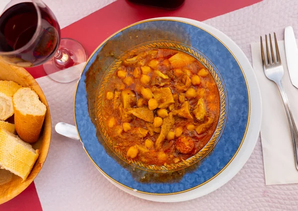 吃西班牙菜 在沙司中加入蔬菜 牛油果豆 熏肉和什锦香肠等调味的三文鱼排作为主菜 — 图库照片