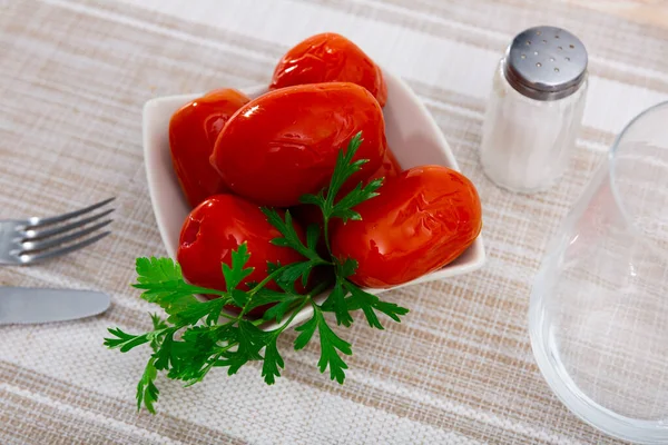 Talerz Marynowanymi Pomidorami Ozdobiony Gałązką Świeżej Pietruszki Podawanej Obiad Stole — Zdjęcie stockowe