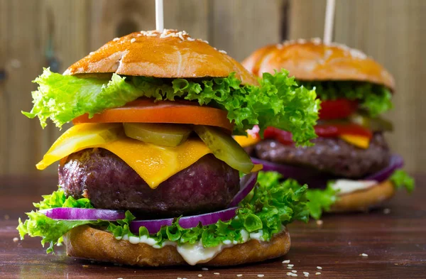 Two Juicy Hamburgers Cheese Fresh Tomatoes Onion Lettuce Leaves Wooden — Stockfoto