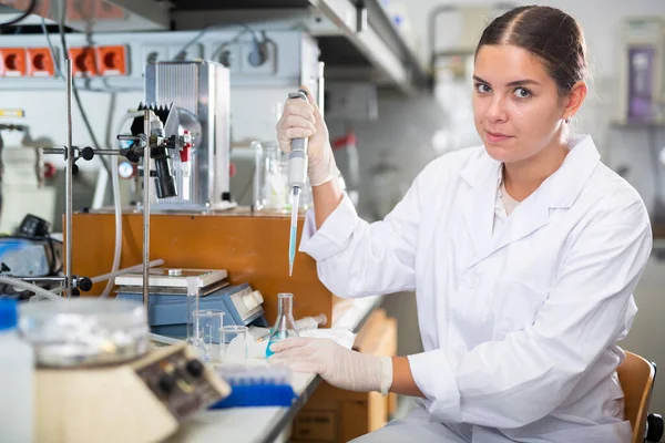 Lächelnde Chemikerin Pipettiert Blaues Reagenz Lösung Reagenzglas Während Sie Experimente — Stockfoto