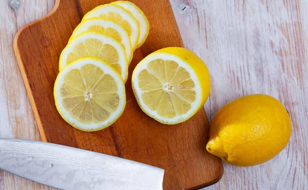 木のテーブルの上に完全にスライスされた熟した有機レモン — ストック写真