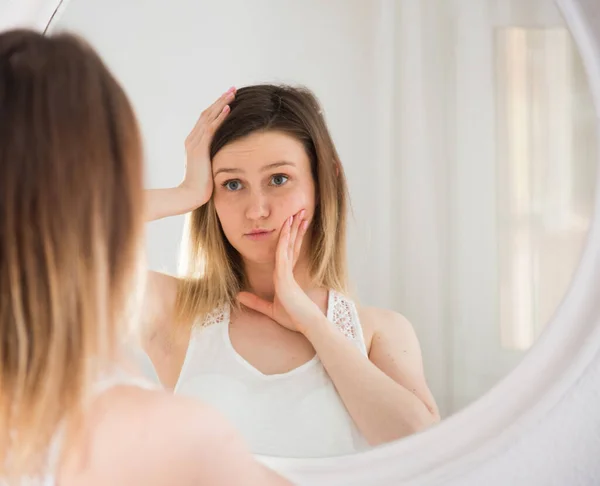 Genç Kadın Aynayı Kullanıyor Sabah Yatak Odasında Yüzüne Dokunuyor — Stok fotoğraf