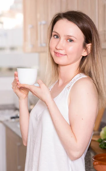 若い女性は自宅でお茶とポーズをとっています — ストック写真