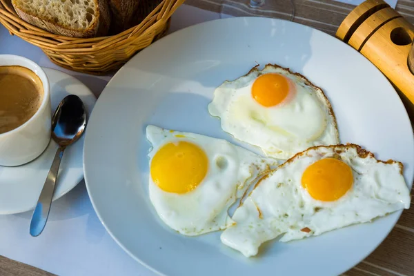 在盘子里放有煎蛋的盘子和一杯咖啡 在咖啡馆里吃早餐的图像 — 图库照片