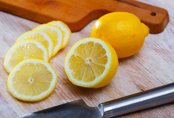 木のテーブルの上で新鮮なジューシーなレモンをスライス 柑橘類の健康上の利点の概念 — ストック写真