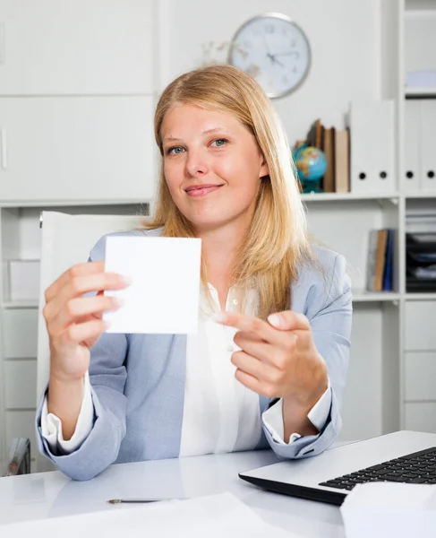 积极的女商务顾问坐在办公室桌旁 给她贴上带有版权的白色贴纸 — 图库照片