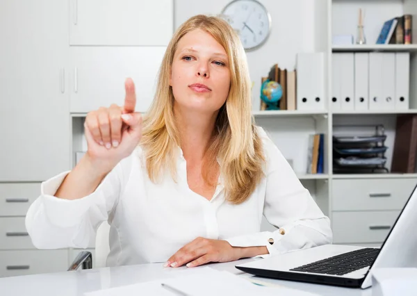 Positive Geschäftsfrau Sitzt Mit Laptop Arbeitsplatz Und Zeigt Auf Unsichtbaren — Stockfoto
