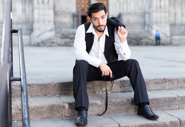 大聖堂の近くの階段に座っている思慮深い髭の男 — ストック写真