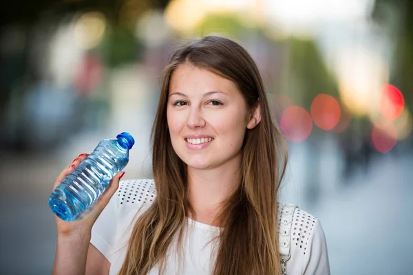 炎热的夏天 一个迷人的女孩在城市里散步时喝水 — 图库照片