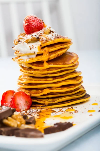 Pumpkin pancakes recipe - mix pumpkin puree with eggs, olive oil, salt, sugar, milk until well combined. Fry in pan without oil. Serve with honey, chocolate, cream, fruits