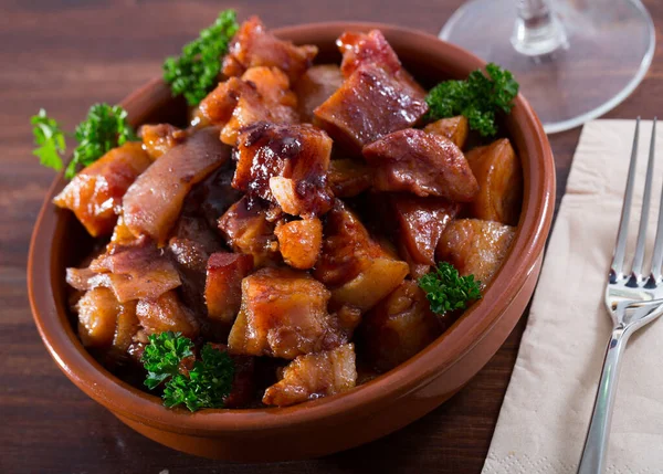 おいしいスペイン料理モロ セルド 焼きたてのパセリと粘土ボウルで提供される豚の切り身 — ストック写真