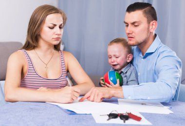 Sad woman with crying boy signing documents about share of property clipart