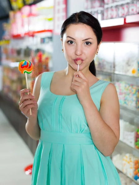 Mujer Joven Chupando Lolly Tienda Caramelos —  Fotos de Stock