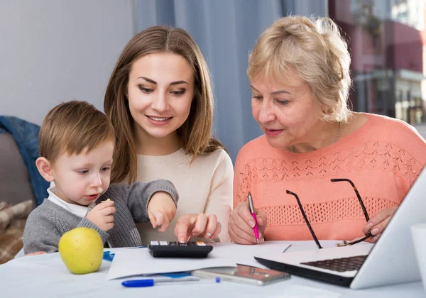 老女は家で娘と孫とノートパソコンの近くで技術をマスターしている — ストック写真
