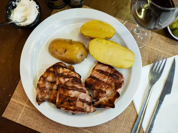 半熟土豆烤猪肉软骨素的丰盛晚餐 用香菜小枝装饰 — 图库照片