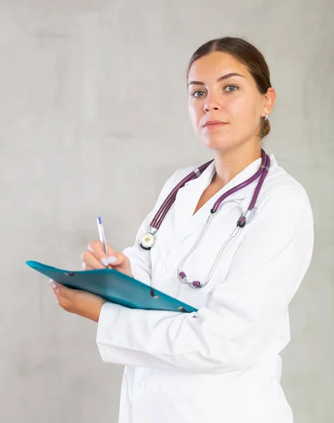 Retrato Una Joven Médica Uniforme Médico Haciendo Notas Carpeta Estudio —  Fotos de Stock