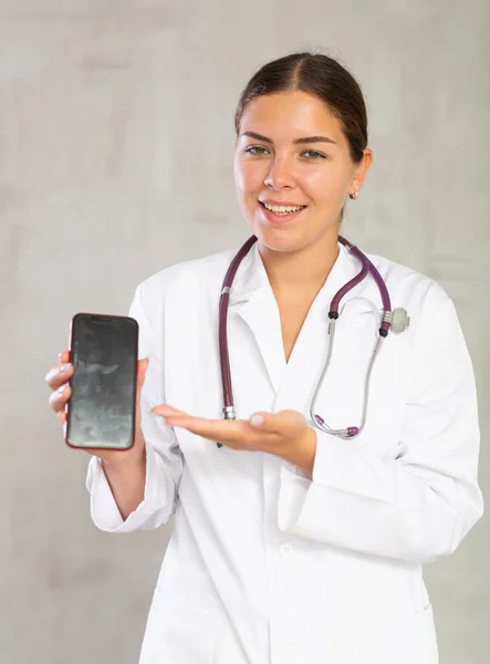 Uśmiechnięta Lekarka Pokazująca Ekran Swojego Smartfona — Zdjęcie stockowe