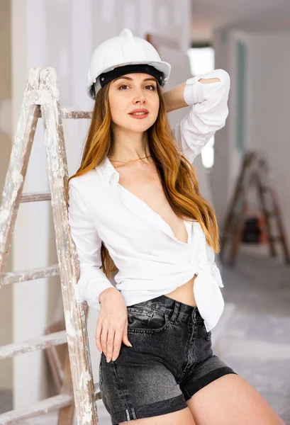Young Seductive Woman Wearing Revealing Clothes Helmet Posing Apartment Repair – stockfoto