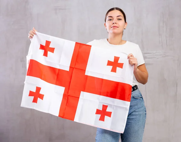 Впевнена Молода Жінка Повсякденному Одязі Тримає Прапор Грузії Сірому Фоні — стокове фото