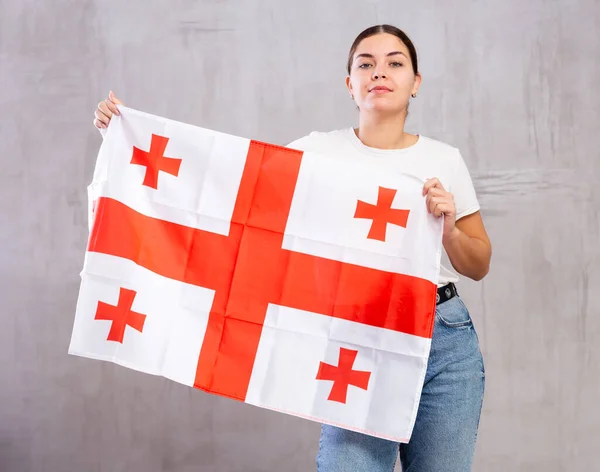 Jovem Confiante Desgaste Casual Segurando Bandeira Geórgia Contra Fundo Cinza — Fotografia de Stock