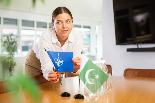 Young Woman Business Clothes Puts Flags Nato Pakistan Negotiating Table — Stock Photo, Image