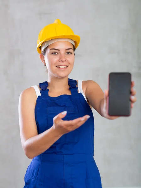 Trabalhador Feminino Alegre Macacões Hardhat Mostrando Tela Seu Telefone — Fotografia de Stock