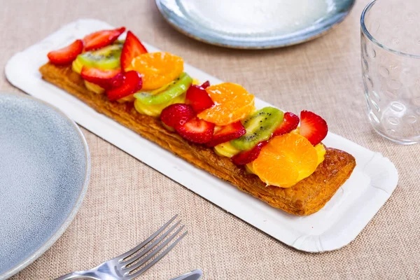 美味的长方形酥酥糕点蛋糕 配上精致的奶油和成熟的橘子 猕猴桃和草莓片 受欢迎的西班牙语招待 — 图库照片