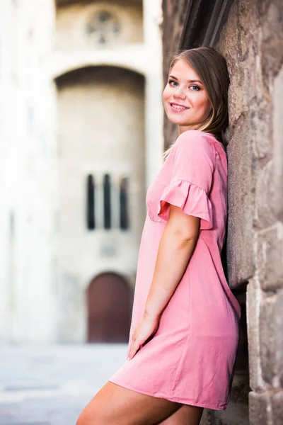 バルセロナの歴史的中心部の石の壁の近くに若い笑顔の女性 — ストック写真