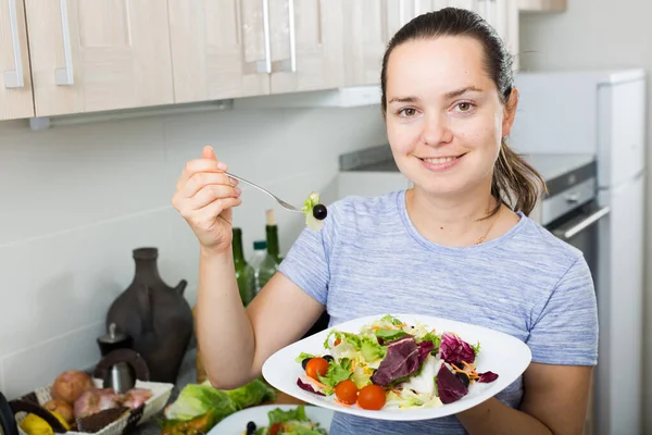 笑顔の若い女性の肖像 家庭でキッチンで新鮮な緑のサラダを食べる — ストック写真