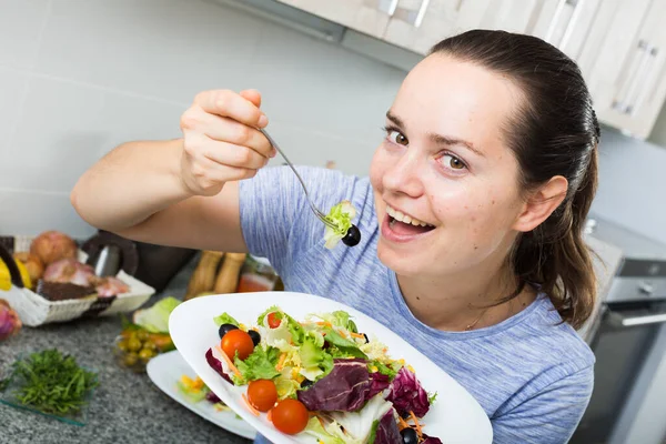 笑顔の若い女性の肖像 家庭でキッチンで新鮮な緑のサラダを食べる — ストック写真