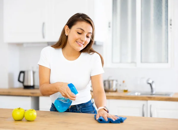 正の若い女性は家をきれいに保ち 日中は新鮮 キッチンテーブルを掃除 — ストック写真