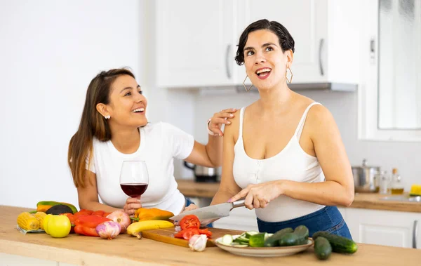 两个快乐的西班牙裔年轻室友在家里的厨房里共度周末 一起喝酒 一起准备菜菜 — 图库照片
