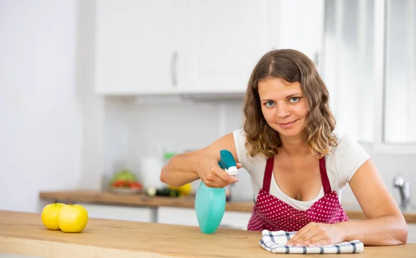 正の若い女性は家をきれいに保ち 日中は新鮮 キッチンテーブルを掃除 — ストック写真