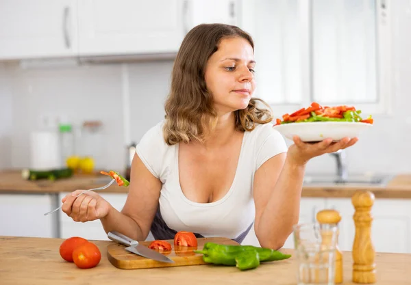 Genç Pozitif Kadın Yemek Pişirdikten Sonra Mutfakta Salata Yiyor — Stok fotoğraf