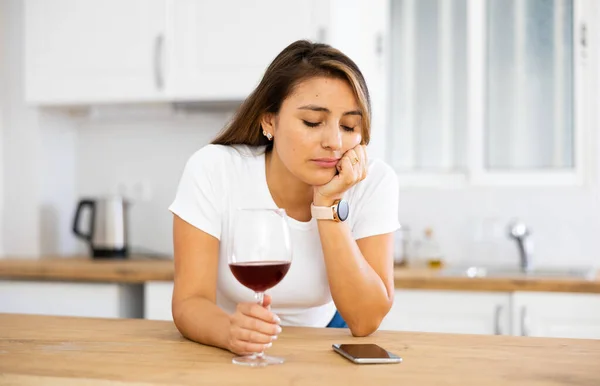 Upset Young Woman Glass Red Wine Kitchen Reading Messages Mobile — Stock Photo, Image