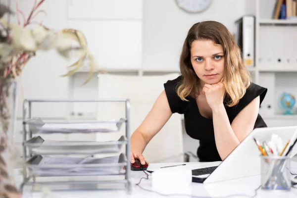 現代のオフィスでノートパソコンの後ろで熱心に働くビジネス女性 — ストック写真