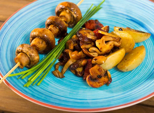 stock image Grilled champignons on skewer, assorted roasted mushrooms and baked potatoes with green onion