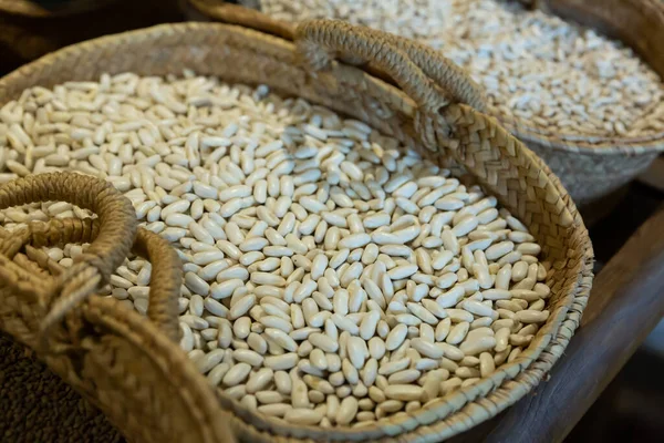 在当地加泰罗尼亚市场上的篮子里 干了的白色软糖豆 — 图库照片