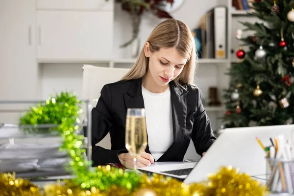 사무직 근로자가 크리스마스 기간에 책상에 앉아서 작업을 — 스톡 사진